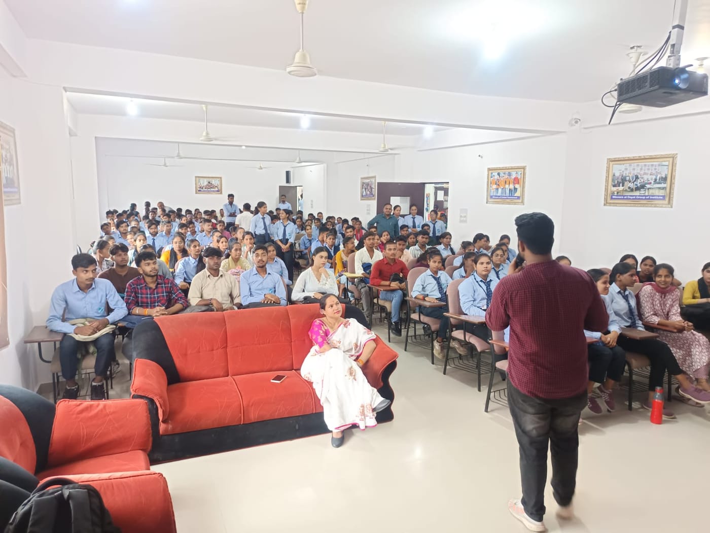 Students seated in a college hall listening to a facilitator during an AI readiness session.
